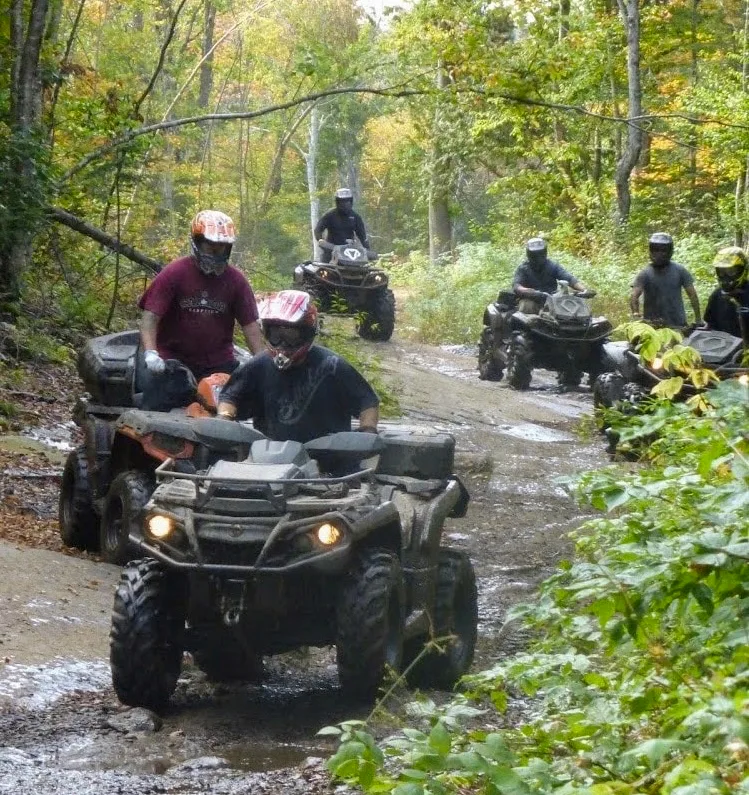 ATV riders on a forest trail in Algonquin West ATV Club territory in Ontario.