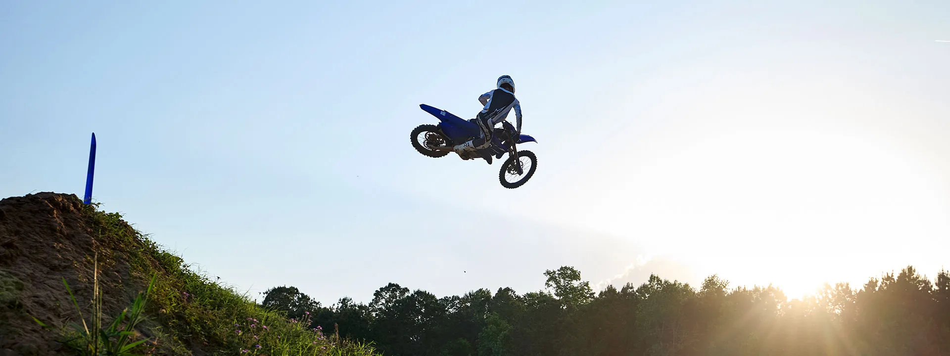 Yamaha off-road motorcycle rider jumping on a motocross track during BLU CRU demo tour promotion.