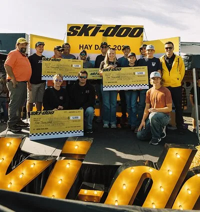 Ski-Doo Snow PASS grant recipients holding funding cheques at Hay Days 2026.