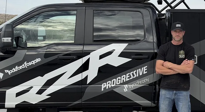 Kyle Chaney beside a Polaris RZR Factory Racing support truck.