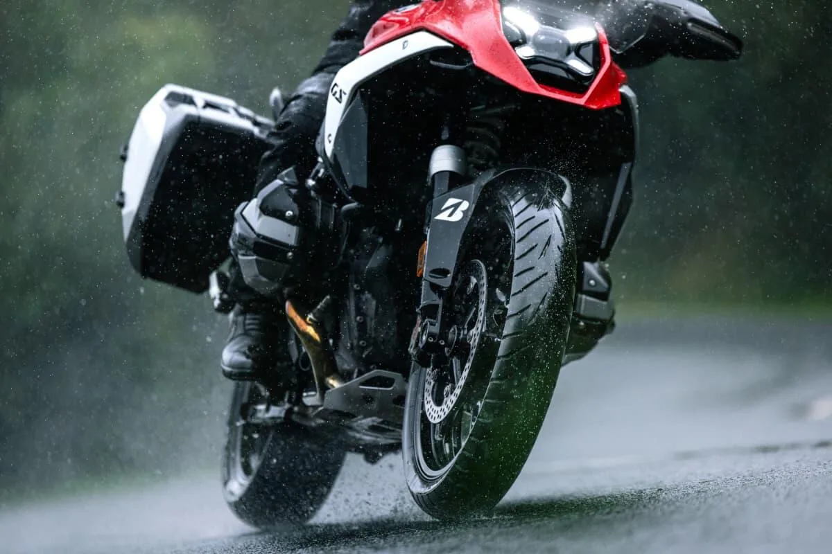 Adventure motorcycle riding through water during Bridgestone’s official Battlax Adventure A42 wet-road demonstration