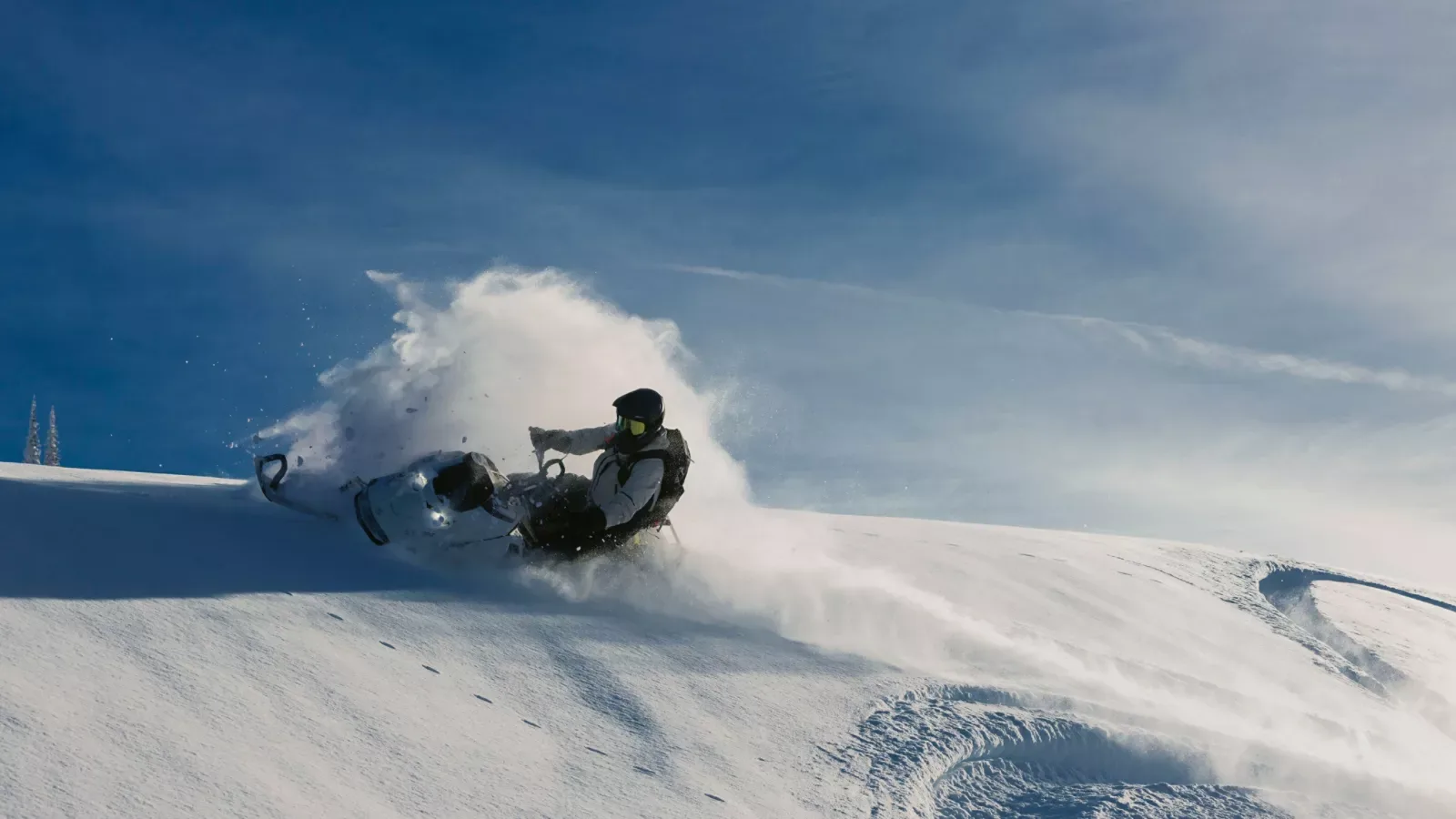 Woman riding a Ski-Doo Summit through deep mountain snow.