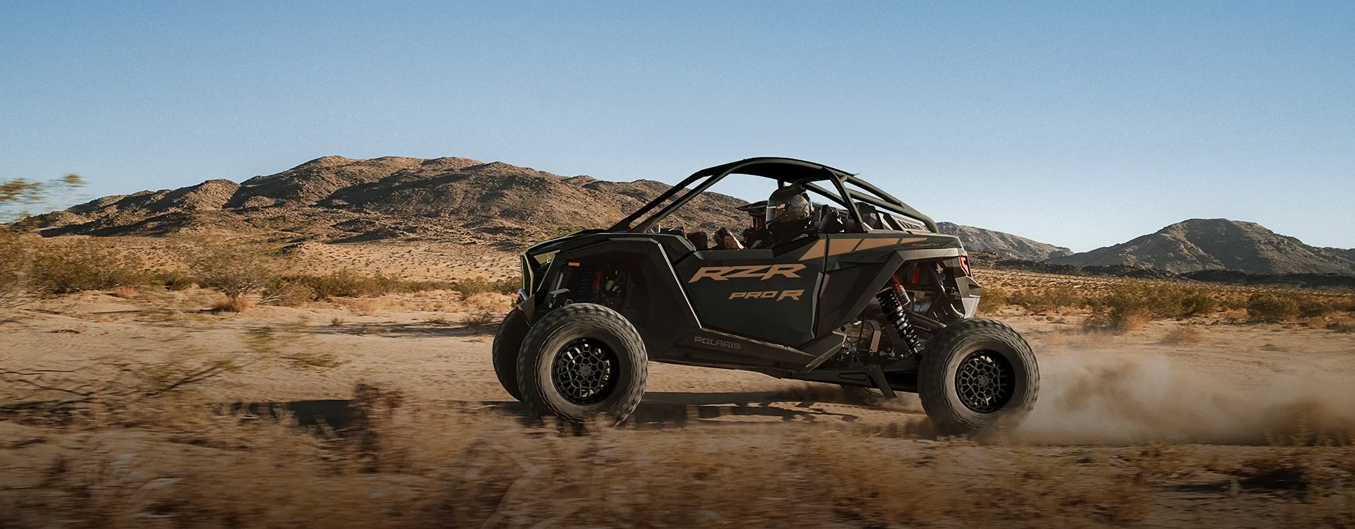 A production Polaris RZR Pro R being driven on desert terrain.