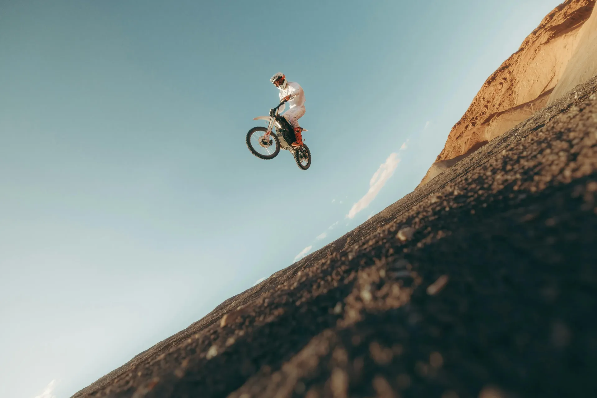 Zero XE electric off-road motorcycle jumping on a dirt riding area