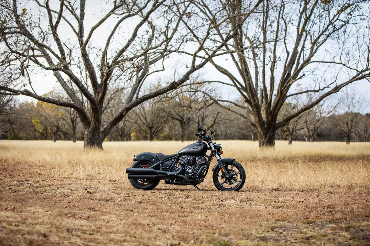Black 2026 Indian Chief Dark Horse parked on grass with trees behind it