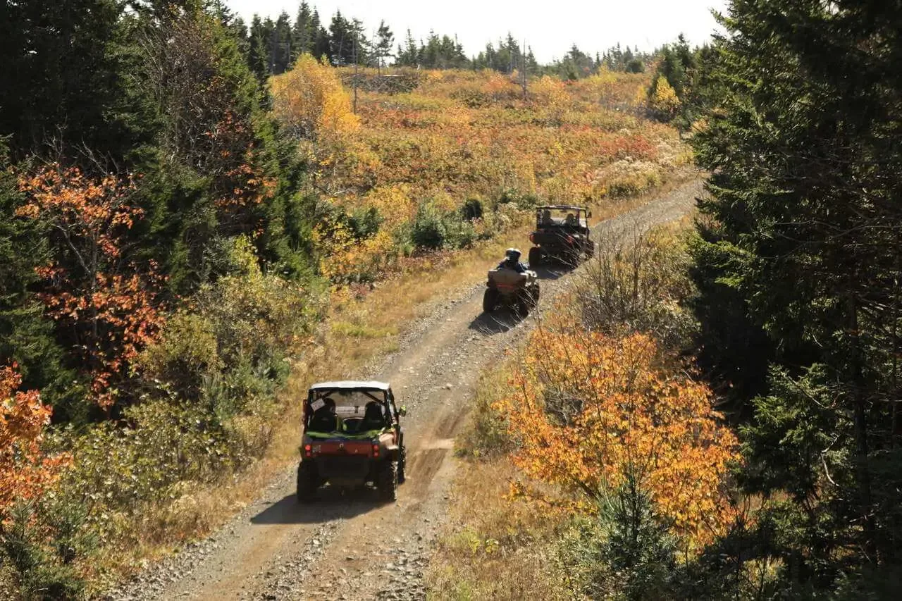 ATVs and side-by-sides riding a Prince Edward Island dirt trail in autumn
