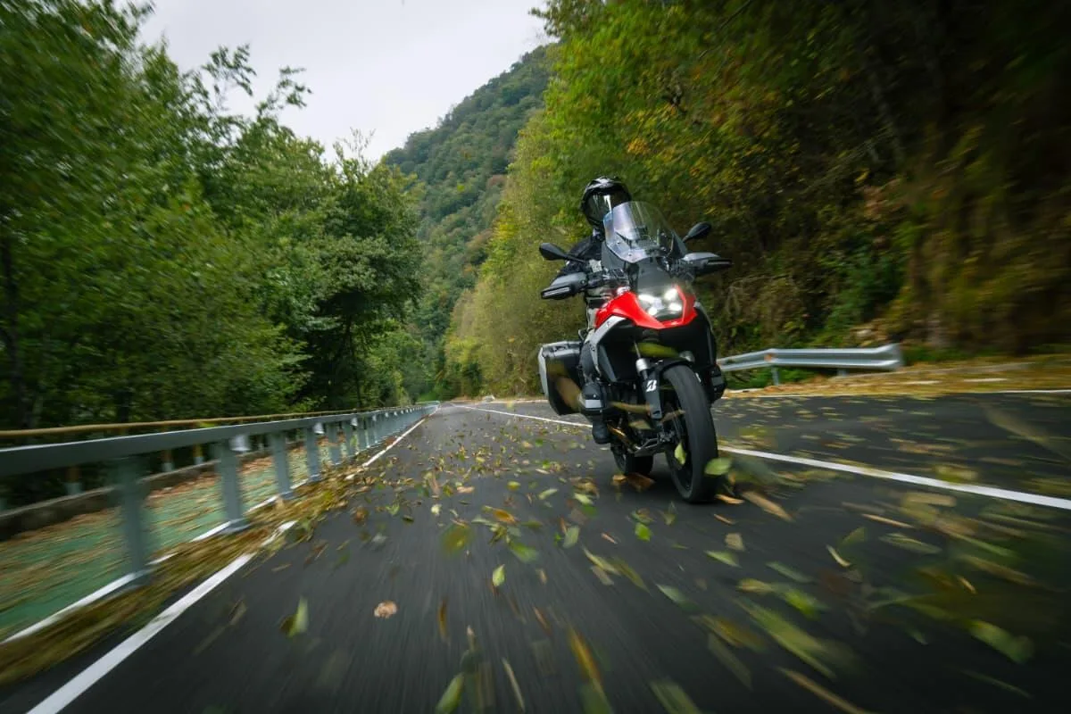 Adventure motorcycle on a wooded paved road in Bridgestone’s official Battlax Adventure A42 launch photography